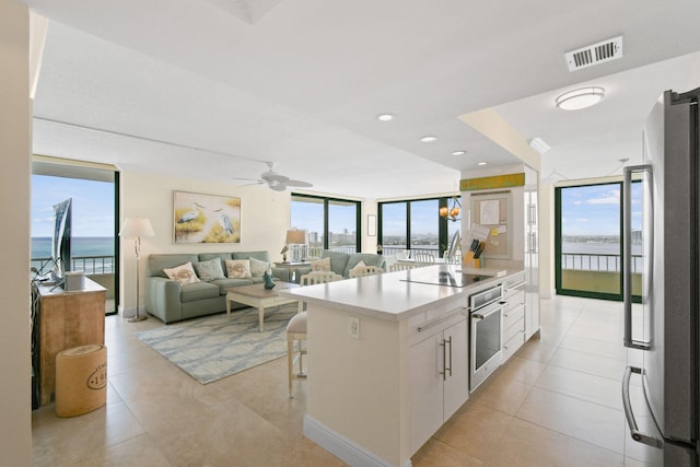 kitchen with visible vents, white cabinets, stainless steel appliances, and expansive windows