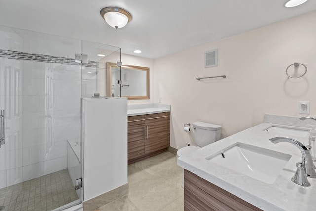 bathroom with tile patterned floors, vanity, toilet, and a shower with door