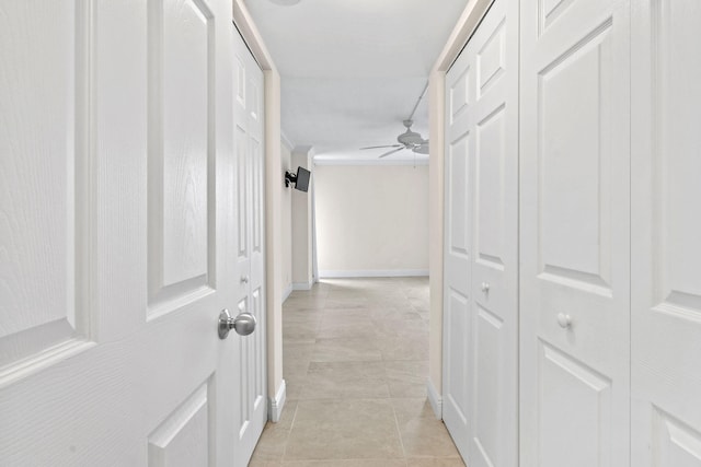 hall with light tile patterned floors and baseboards