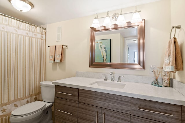 bathroom featuring toilet, vanity, and a shower with curtain