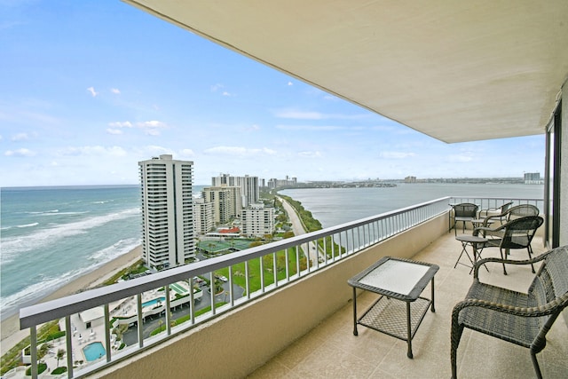 balcony featuring a beach view and a water view