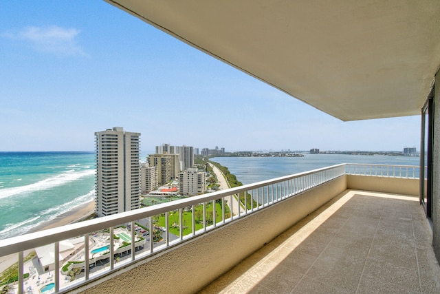 balcony featuring a view of the beach and a water view