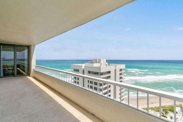 balcony with a water view and a beach view