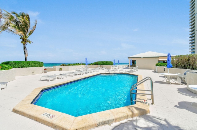 view of pool featuring a patio area and a water view