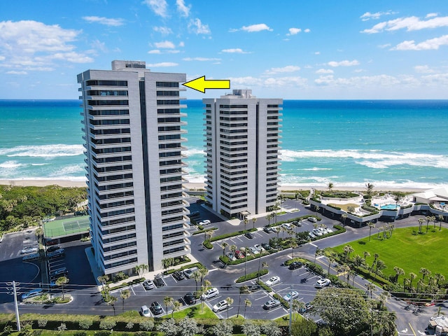 birds eye view of property featuring a water view and a beach view