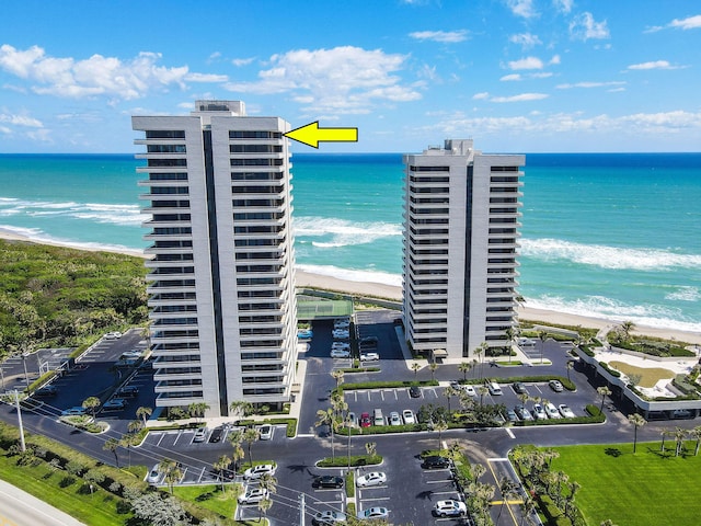 birds eye view of property with a water view and a beach view