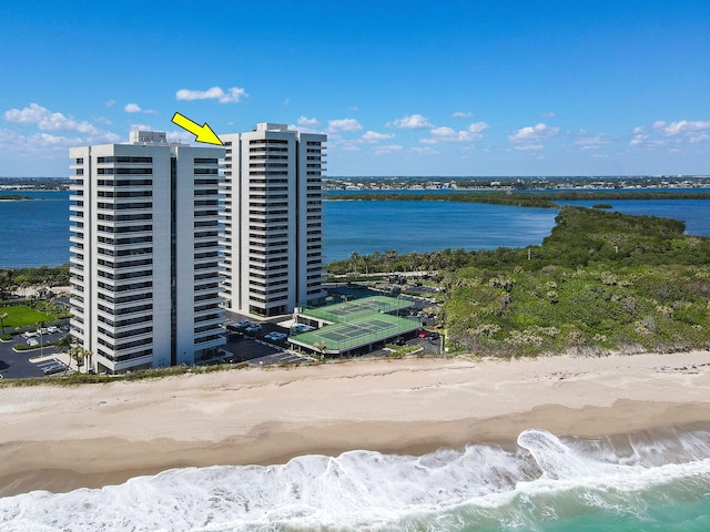 birds eye view of property with a water view and a beach view