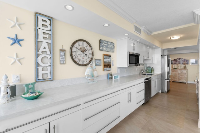 kitchen with decorative backsplash, appliances with stainless steel finishes, crown molding, sink, and white cabinets