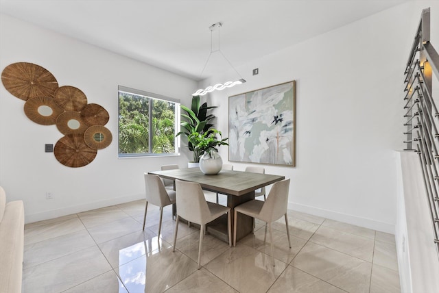 dining room featuring a barn door and light tile patterned floors