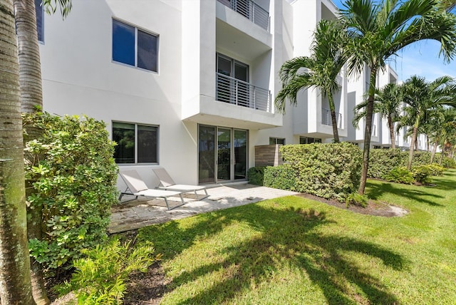 back of house featuring a balcony, a yard, and a patio