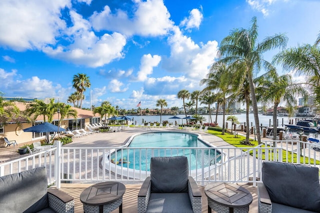 view of swimming pool with a patio and a water view