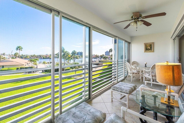 sunroom / solarium with a water view and ceiling fan