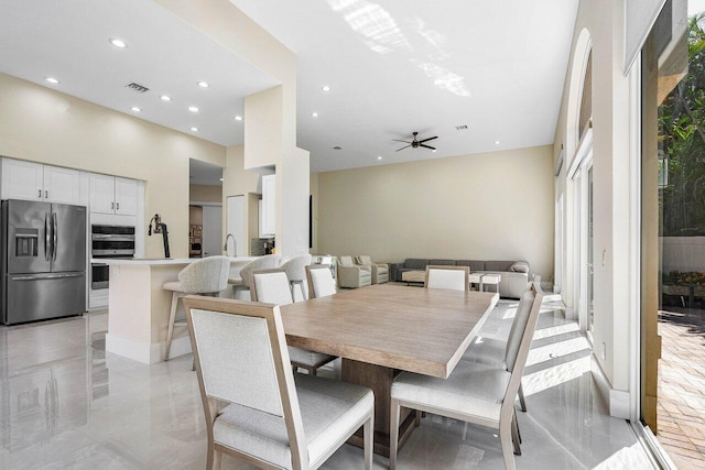 dining space featuring a high ceiling and ceiling fan