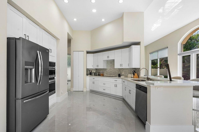 kitchen featuring appliances with stainless steel finishes, sink, white cabinets, and decorative backsplash