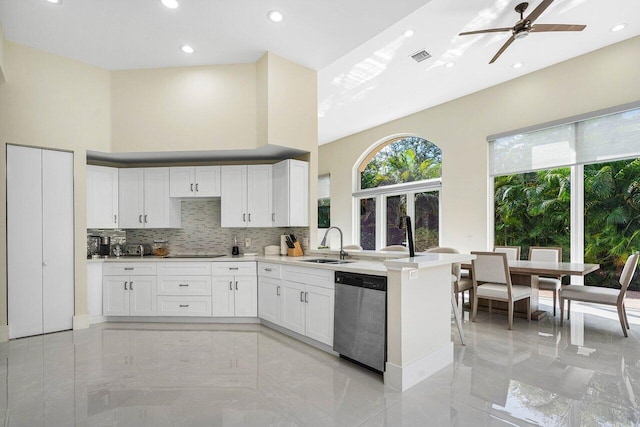 kitchen featuring tasteful backsplash, stainless steel dishwasher, sink, ceiling fan, and white cabinets