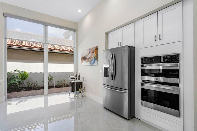 kitchen featuring stainless steel appliances and white cabinetry