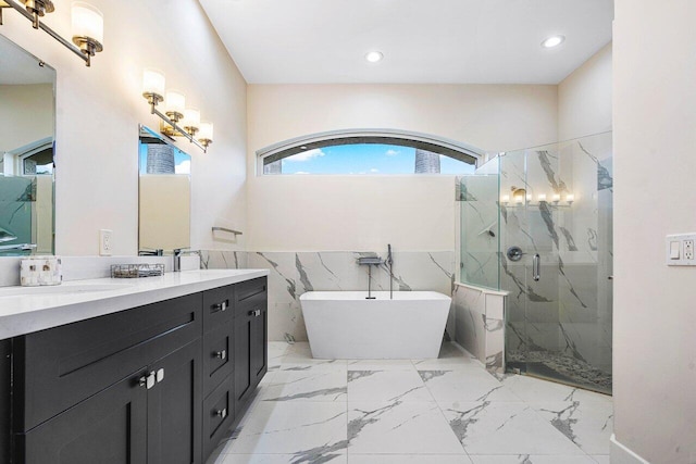 bathroom featuring vanity, independent shower and bath, and tile walls