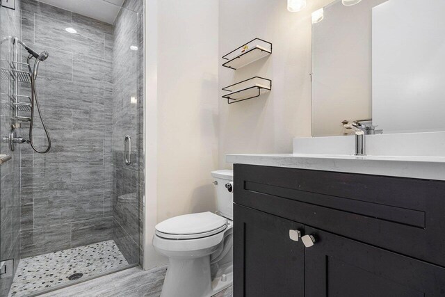 bathroom with a shower with door, vanity, toilet, and hardwood / wood-style flooring