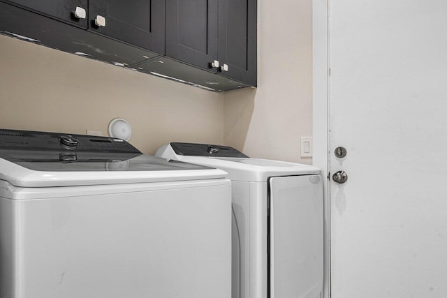 washroom with independent washer and dryer and cabinets