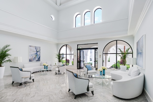 living room featuring a towering ceiling and ornamental molding