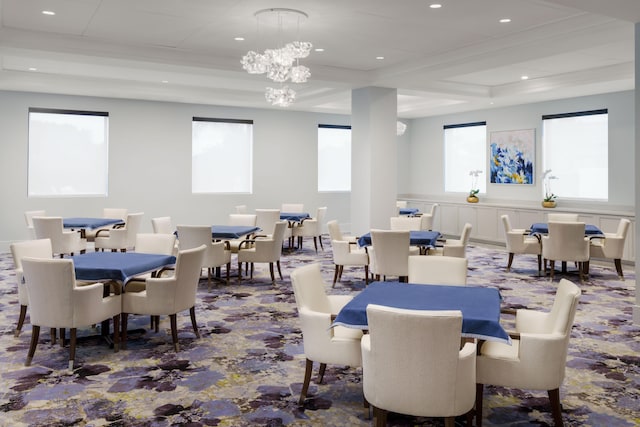 interior space with a raised ceiling, ornamental molding, and a chandelier