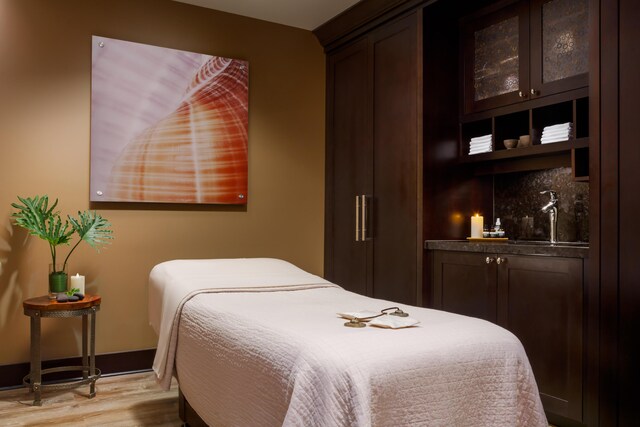 bedroom featuring sink and light hardwood / wood-style flooring