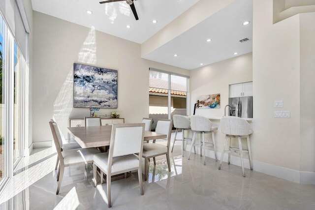 dining area with a high ceiling and ceiling fan