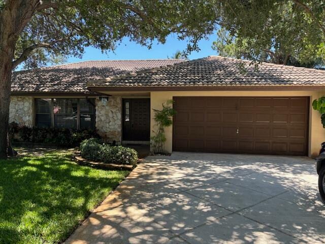 ranch-style home featuring a front lawn and a garage