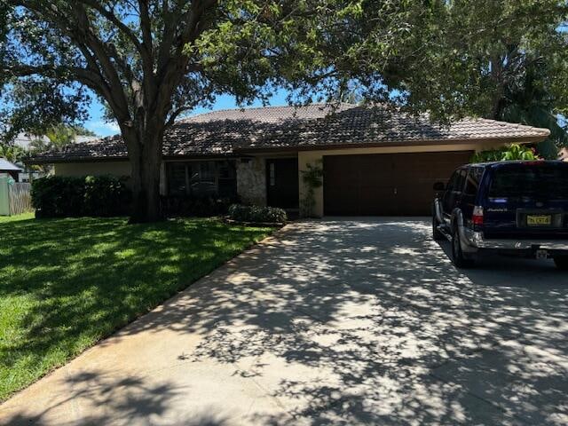 single story home with a front yard and a garage