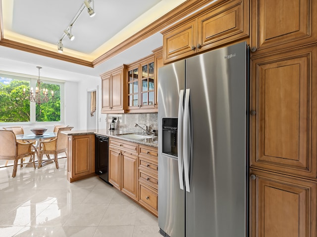 kitchen featuring light stone countertops, sink, a notable chandelier, hanging light fixtures, and stainless steel refrigerator with ice dispenser