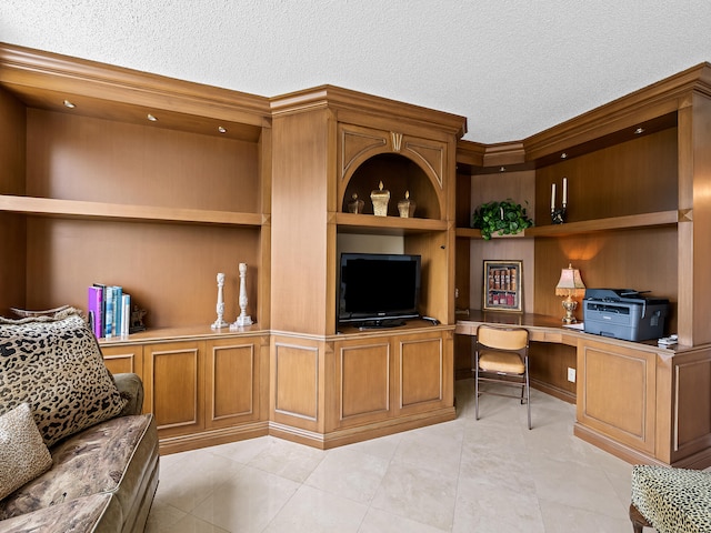 office space with built in features, ornamental molding, a textured ceiling, and built in desk