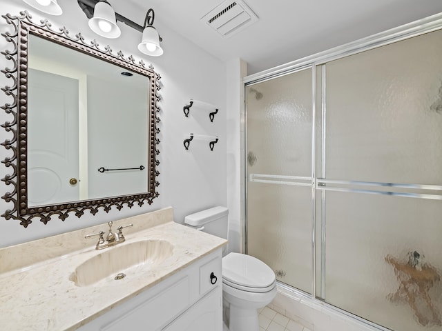 bathroom featuring an enclosed shower, vanity, tile patterned flooring, and toilet