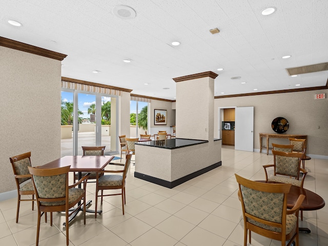 dining area featuring ornamental molding and decorative columns