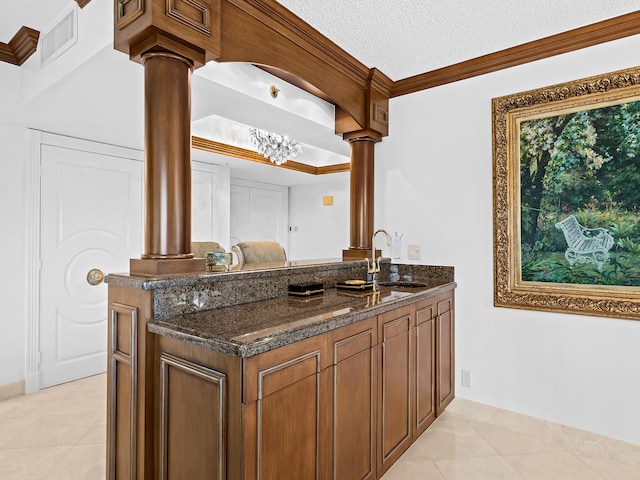 bar featuring ornamental molding, a textured ceiling, dark stone counters, and sink