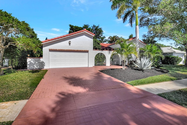 mediterranean / spanish house featuring a front yard and a garage