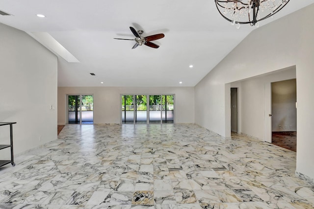 unfurnished living room featuring lofted ceiling and ceiling fan with notable chandelier