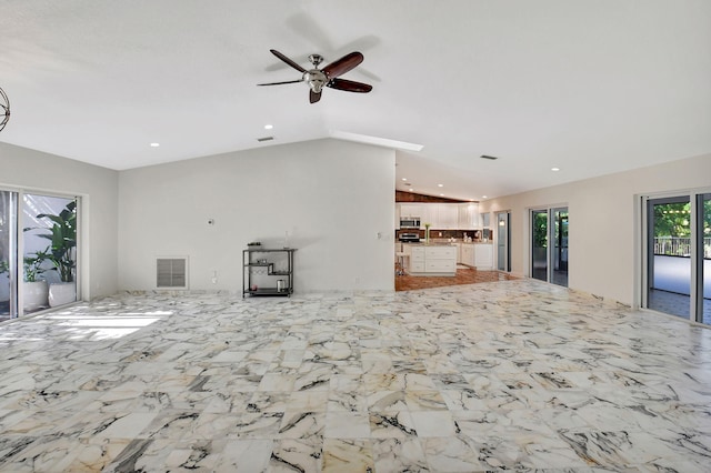 unfurnished living room featuring ceiling fan and vaulted ceiling