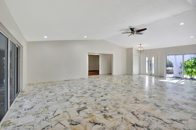 unfurnished living room with ceiling fan with notable chandelier and vaulted ceiling