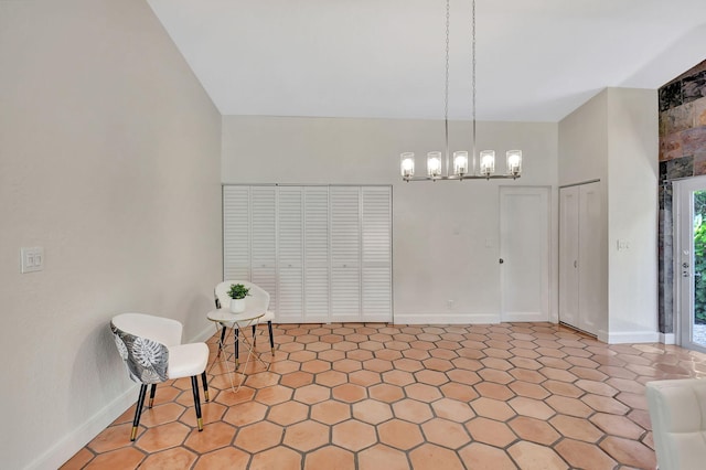 sitting room with tile patterned floors, high vaulted ceiling, and a chandelier