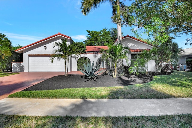 mediterranean / spanish-style house featuring a front lawn and a garage