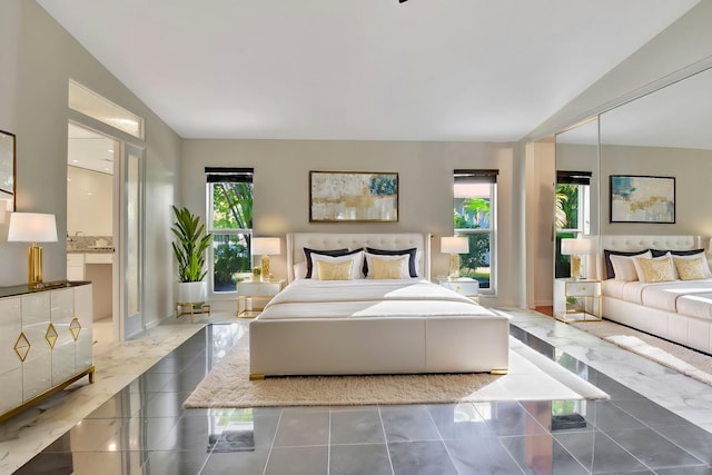 bedroom with multiple windows, a closet, and vaulted ceiling