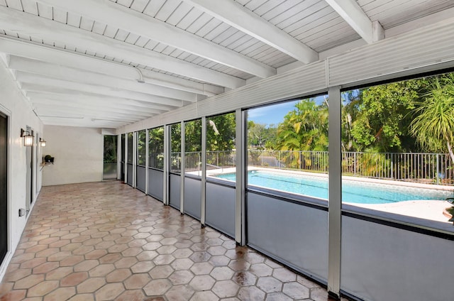 unfurnished sunroom featuring beam ceiling