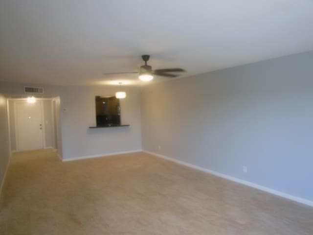 unfurnished room with ceiling fan and light carpet