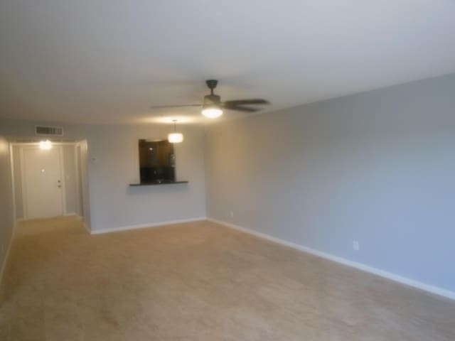 405 US Highway 1 Unit 307, Palm Beach Gardens, FL 33408 - unfurnished living room with a ceiling fan, baseboards, and light carpet