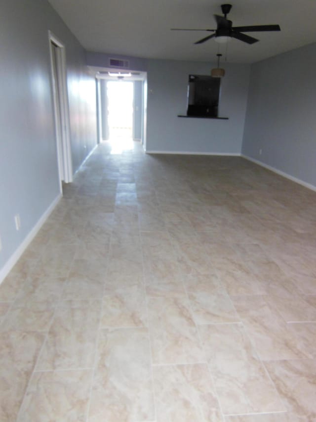 unfurnished living room featuring ceiling fan and light tile patterned floors