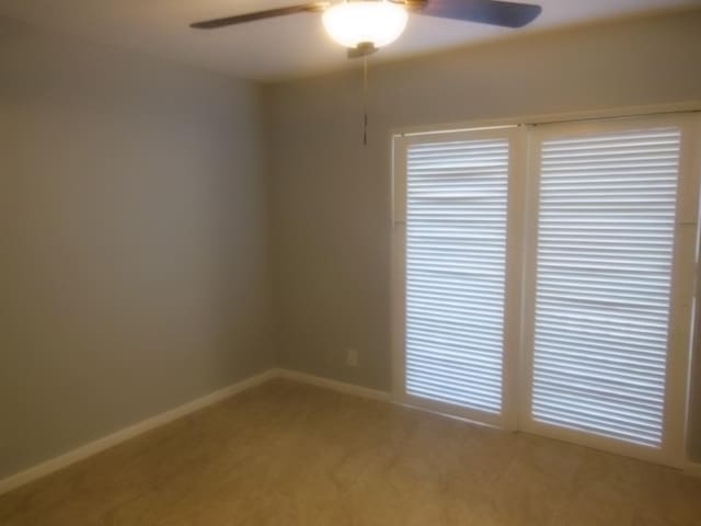 empty room with ceiling fan and carpet flooring