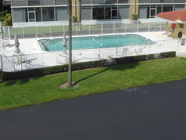 view of swimming pool featuring a lawn and a patio