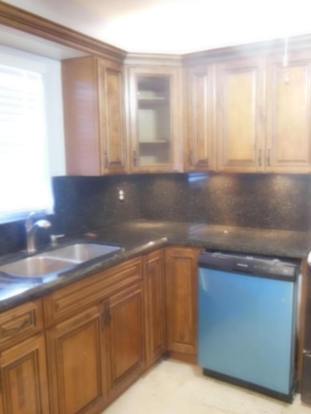 405 US Highway 1 Unit 307, Palm Beach Gardens, FL 33408 - kitchen featuring dishwashing machine, a sink, brown cabinets, dark countertops, and tasteful backsplash