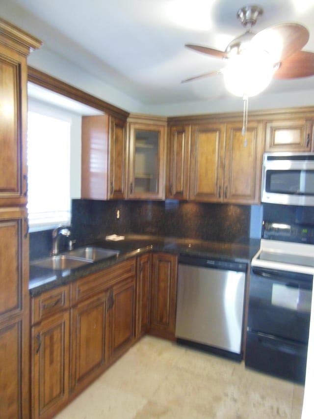 405 US Highway 1 Unit 307, Palm Beach Gardens, FL 33408 - kitchen featuring stainless steel appliances, a sink, decorative backsplash, brown cabinets, and glass insert cabinets