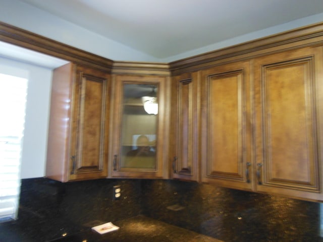405 US Highway 1 Unit 307, Palm Beach Gardens, FL 33408 - kitchen featuring dark countertops, brown cabinets, and glass insert cabinets